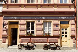 un ristorante con tavoli e sedie fuori da un edificio di Café Havlíček Penzion a Kutná Hora
