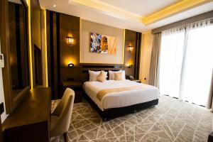 a hotel room with a bed and a desk and a window at Belad Bont Resort in Salalah