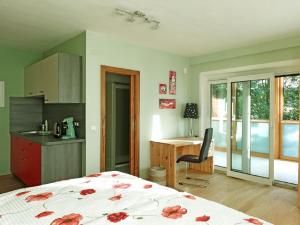 a bedroom with a bed and a desk and a kitchen at Haus Monti in Maria Lanzendorf