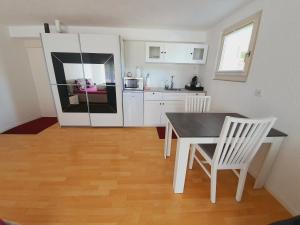 a kitchen with a table and chairs and a refrigerator at Ferienzimmer Arth am See in Arth