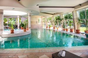 a swimming pool in a hotel with plants at Residence Hotel Balaton in Siófok