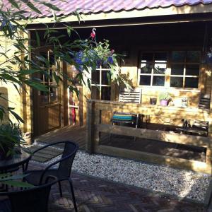 a patio with two chairs and a bench in front of a house at Tiny House Andersom Anders in Bad-Nieuweschans