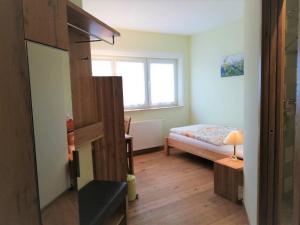 um pequeno quarto com uma cama e uma janela em Haus Monti em Maria Lanzendorf