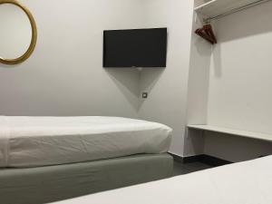 a bedroom with a bed and a flat screen tv at Jazz Hotel in Naples