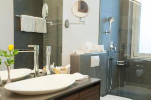 a bathroom with a sink and a shower at Romantik Hotel Beau Rivage Weggis - Beau Rivage Collection in Weggis