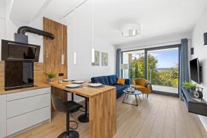 a kitchen and living room with a table and a couch at Natural Baltic Darłówko Emilia Strupiechowska in Darlowko