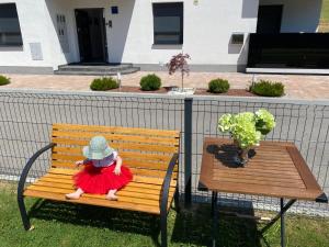 a doll sitting on a bench next to a table at Apartments Dora Sveti Martin na Muri in Sveti Martin na Muri