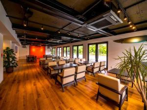 a conference room with tables and chairs and windows at HOTEL R9 Kujukuri "ex Casual Resort COFF Ichinomiya" in Ichinomiya