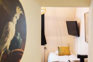 Hanze Hotel Zwolle في زفوله: غرفة بها سرير وتلفزيون على الحائط