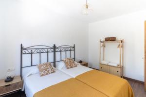 um quarto com uma cama com um cobertor amarelo em Housingleón - Atico Gaudí em León