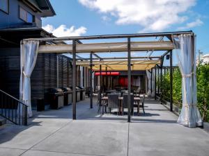 a patio with a table and chairs under awning at HOTEL R9 Kujukuri "ex Casual Resort COFF Ichinomiya" in Ichinomiya