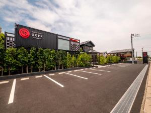 an empty parking lot with a sign for a coffee store at HOTEL R9 Kujukuri "ex Casual Resort COFF Ichinomiya" in Ichinomiya