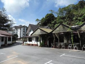 a building with tables and chairs in a parking lot at Cameronian Inn in Cameron Highlands
