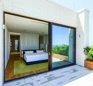 a bedroom with a bed and sliding glass doors at PRIVE The Luxury Villa & Boutique Hotel, Cape of Rodon in Draç +53 photos