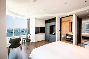 釜山にあるAG405 Hotelのベッドルーム1室(大型ベッド1台付)、デスクが備わります。