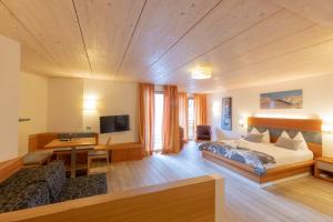 a hotel room with a bed and a desk at Berghotel Miramonti in Tesero