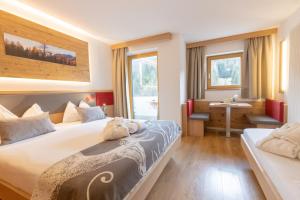 a hotel room with two beds and a sink at Berghotel Miramonti in Tesero +46 photos