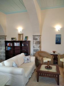 Una sala de estar con un sofá blanco y una mesa. en Apartment Gialos, en Symi