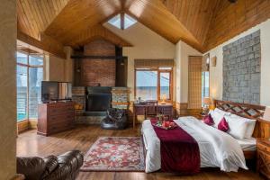a living room with a bed and a fireplace at StayVista at Wood House Retreat in Shimla