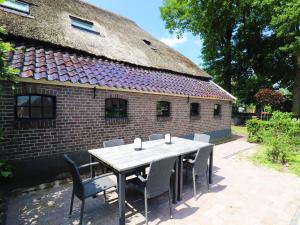 uma mesa e cadeiras em frente a um edifício de tijolos em Modern Saxon farmhouse in Dalerveen village em Dalerveen