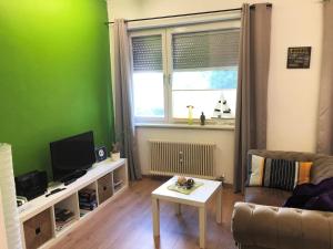 Sala de estar verde con sofá y mesa en Lighthaus Apartment en Graz