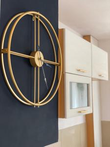 a large gold clock on a blue wall at Vicky - New Apartment Centrum Srodmiescie in Warsaw