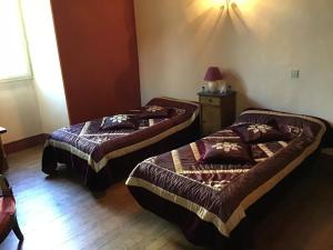 dwa łóżka pojedyncze w pokoju z lampą w obiekcie Maison Laclede w mieście Bedous