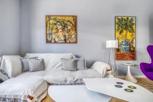 salon z kanapą i obrazami na ścianie w obiekcie Spacious flat with courtyard in Peristeri! w Atenach