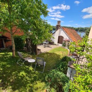 a yard with two chairs and a table and a house at Apartament OLTO Mikołajki in Mikołajki