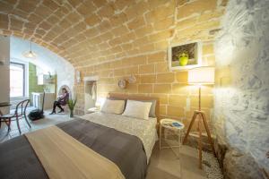 um quarto com uma cama e uma parede de tijolos em La Ferula Magica - alloggio tipico em Minervino Murge