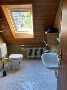 La salle de bains est pourvue de toilettes, d'un lavabo et d'une fenêtre. dans l'établissement Panorama Point, à Sasbachwalden