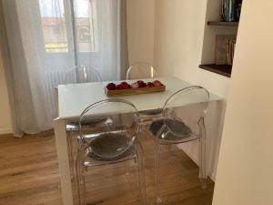 a white table with three chairs and a bowl of apples at ON the RAIL by Arcotrilogy-Homes in Arco