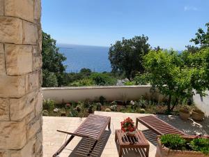 un patio con 2 mesas de picnic y vistas al océano en CASA AL MARE RIO b&n, en Tricase