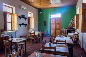 restauracja ze stołami i krzesłami oraz zieloną ścianą w obiekcie Arsinoe w mieście Methana