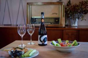 Eine Flasche Wein und zwei Weingläser auf einem Tisch in der Unterkunft Arsinoe in Methana + 38 Fotos