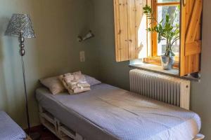 ein Schlafzimmer mit einem Bett, einer Lampe und einem Fenster in der Unterkunft Arsinoe in Methana