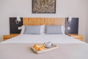 ein Tablett mit Croissants und einer Tasse Kaffee auf dem Bett in der Unterkunft Ona Valle Romano Golf & Resort in Estepona