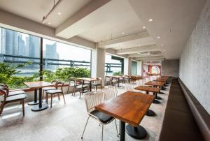 a restaurant with tables and chairs and large windows at AG405 Hotel in Busan