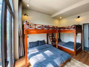 sypialnia z 2 łóżkami piętrowymi w pokoju w obiekcie S'Nghe Homestay Măng Đen w mieście Kon Von Kla