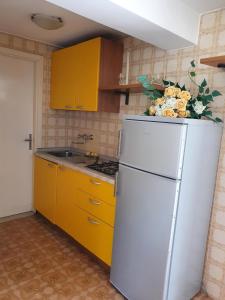 una cucina con frigorifero bianco e armadietti gialli di Annie a Bibione