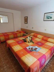 una camera d'albergo con due letti e fiori di Annie a Bibione
