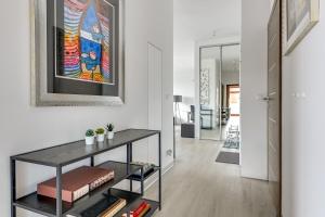 a living room with a table and a painting on the wall at Grand Apartments - Neptun Park. in Gdańsk