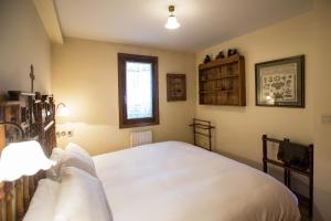 Un dormitorio con una gran cama blanca y una ventana en Wood ✪ WiFi, terraza ✪ Ideal excursiones en Formigal