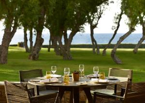 a table with wine glasses on it with a view of the ocean at Neptune Luxury Resort in Mastichari