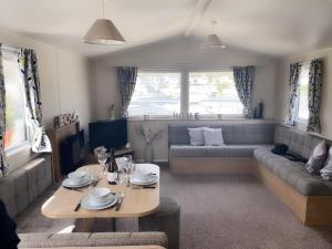 ein Wohnzimmer mit einem Sofa und einem Tisch in der Unterkunft Waterside Holiday Park Paignton Sleep 6 caravan in Paignton