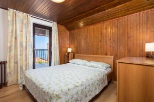 a bedroom with a bed and a window with a balcony at House Obrš in Mošćenička Draga +47 photos