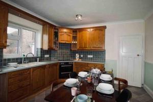 a kitchen with a table with chairs and a sink at Birds Nest in Frinton-On-Sea in Frinton-on-Sea