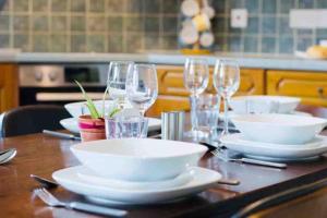 een tafel met witte borden en wijnglazen erop bij Birds Nest in Frinton-On-Sea in Frinton-on-Sea