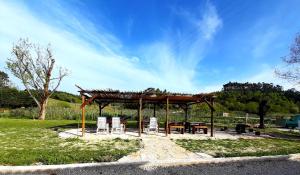 a wooden pavilion with chairs and a picnic table at Valvida in Gaio