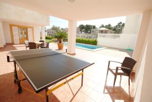 una mesa de ping pong en medio de un patio en Villa Casa Abel with swimming pool en Can Picafort